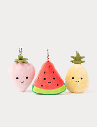 Three plush keychains shaped like a strawberry, watermelon, and pineapple on a white background