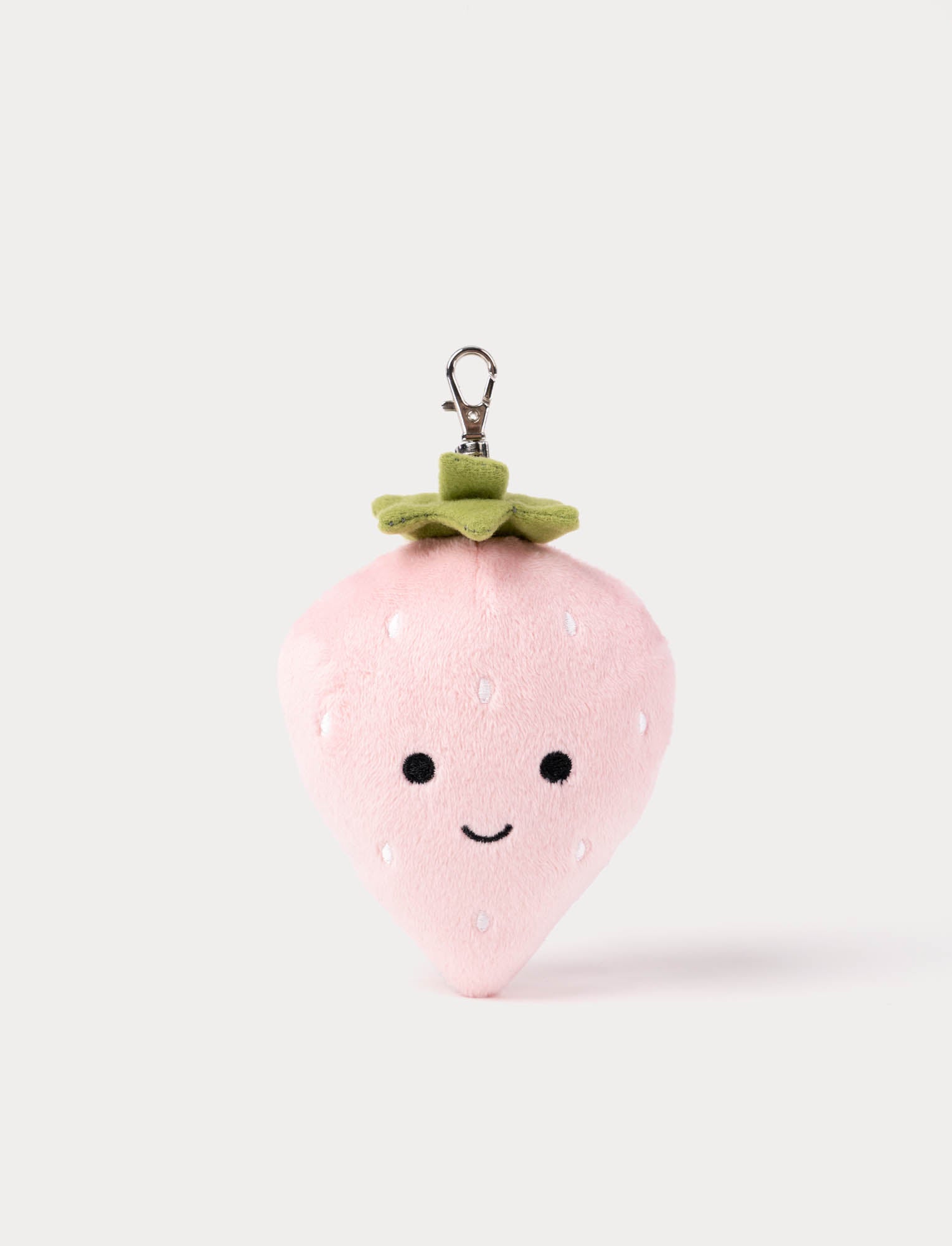  Image of Pink strawberry-shaped plush keychain with a smiling face on a white background