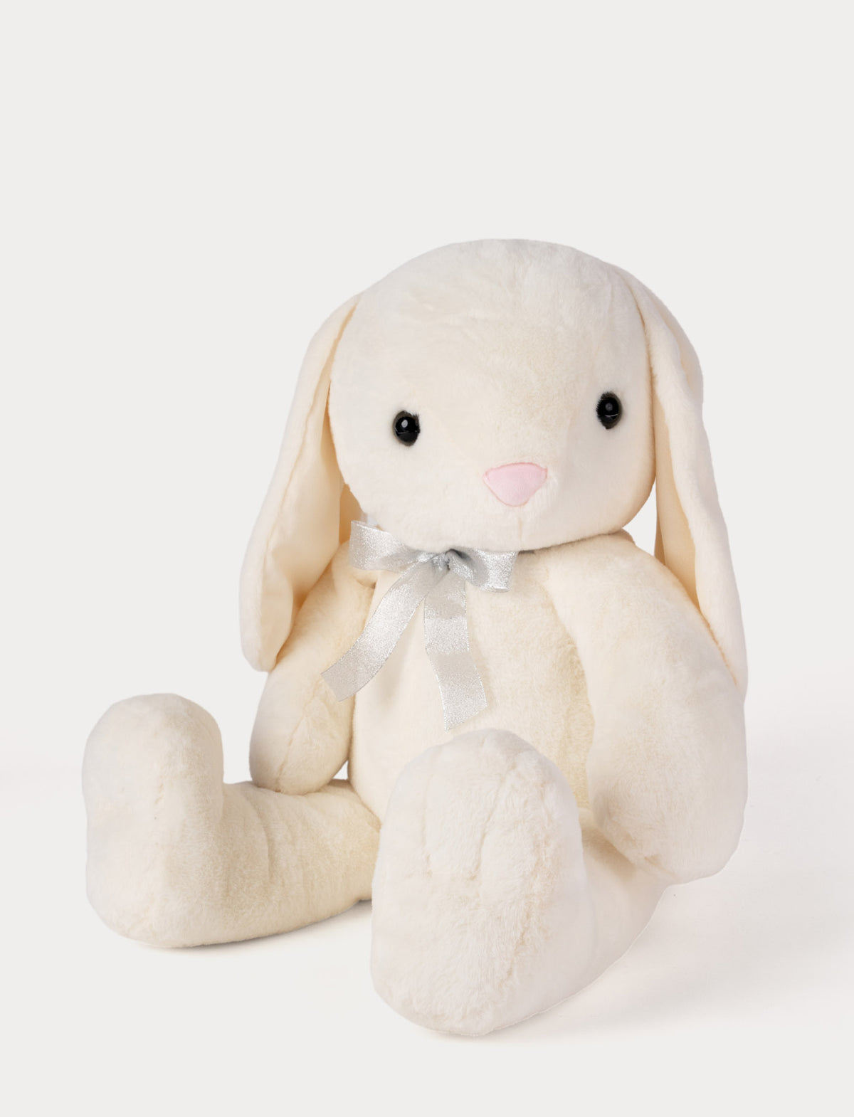 Cream-colored plush bunny toy with a bow tie on a light gray background