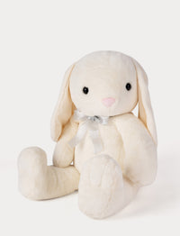 Cream-colored plush bunny toy with a bow tie on a light gray background