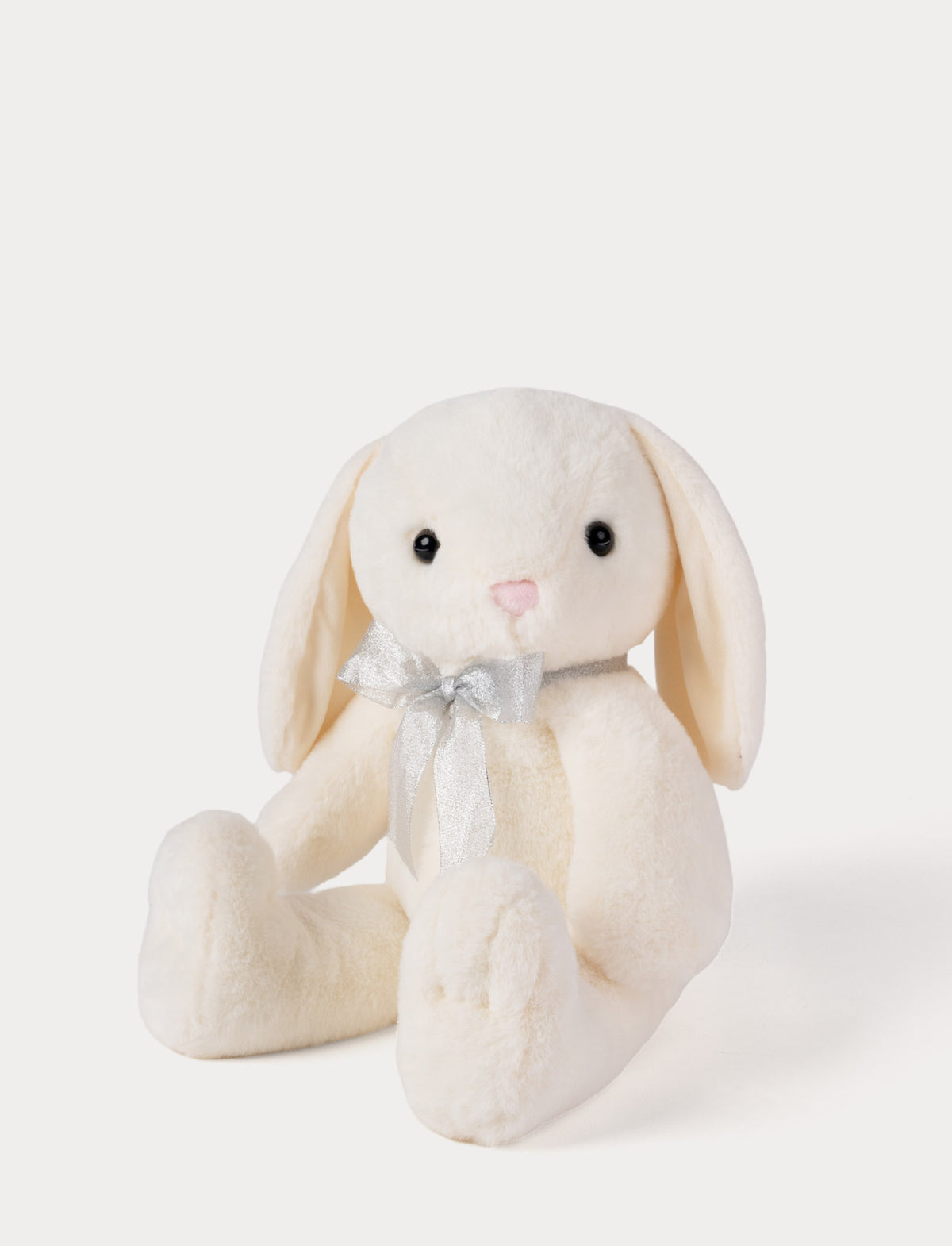 White plush bunny toy with a bow on a white background